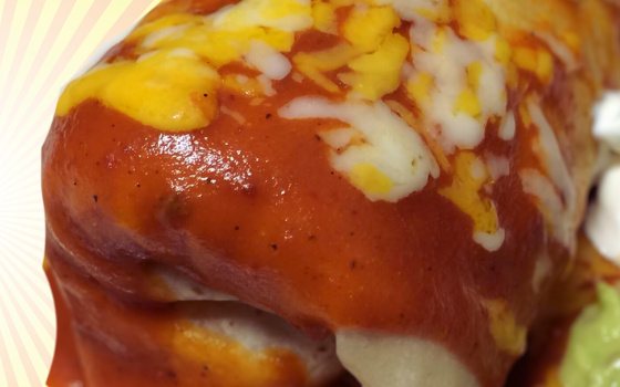 A burrito smothered in red sauce and melted cheese