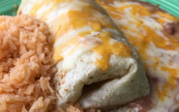 A TacoBurrito with melted cheese, rice and beans